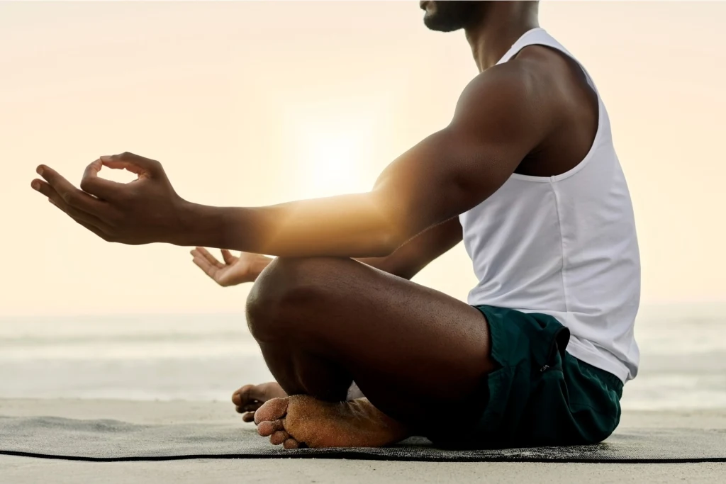 african-american-meditating-outdoors-at-the-beach-during-sunny-morning